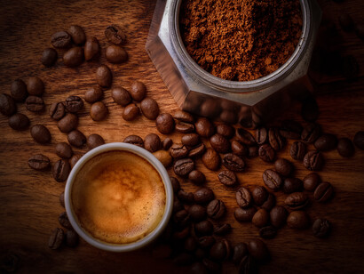 Tasa de café negro junto a una cafetera clásica