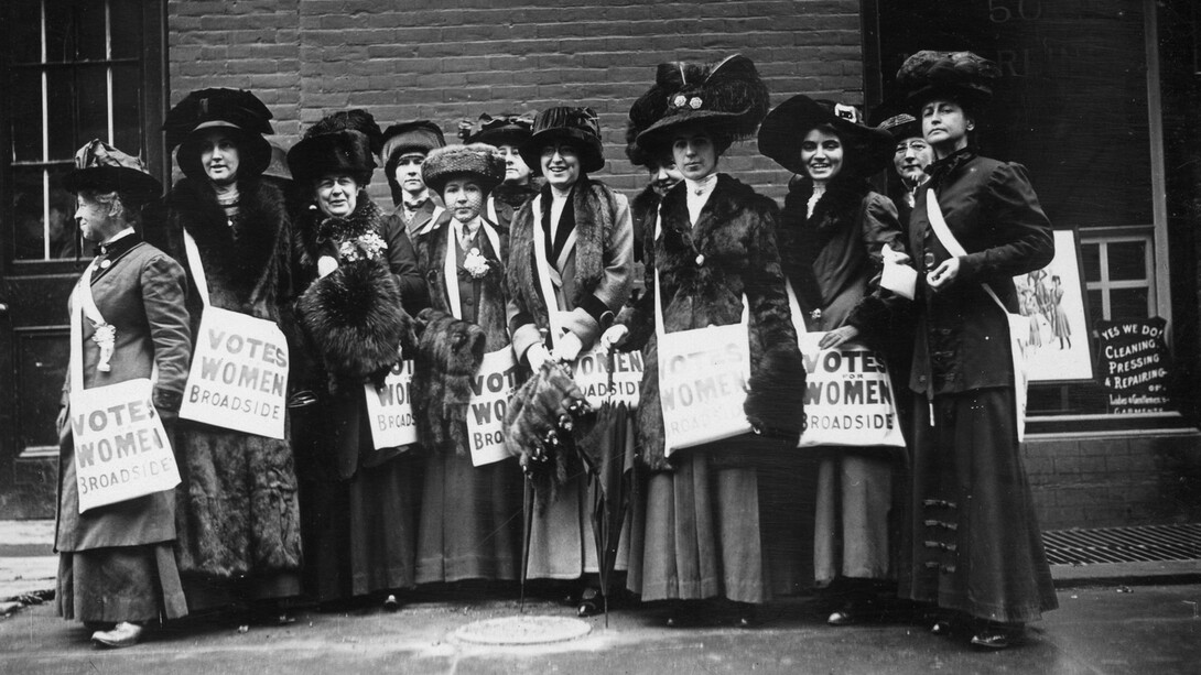 Members of the women's suffrage movement prepare to march on New York's Wall Street in 1913, armed with leaflets and slogans demanding the vote for women