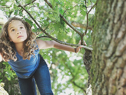 A young learner's tactile connection with a tree, reflecting Rousseau's educational philosophy