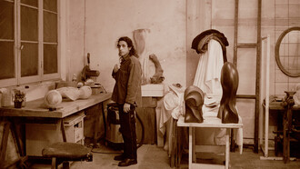 Robby nell'atelier con la testa di falco e altre sculture