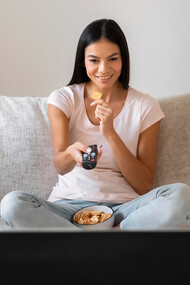A woman enjoys quality time watching her favorite TV shows