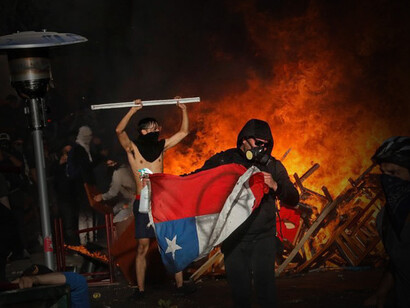 Un hombre sujeta una bandera de Chile durante el Estallido Social en 2019