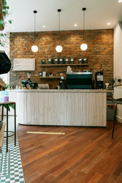 Encargado de un café, esperando en el mostrador de un negocio vacío