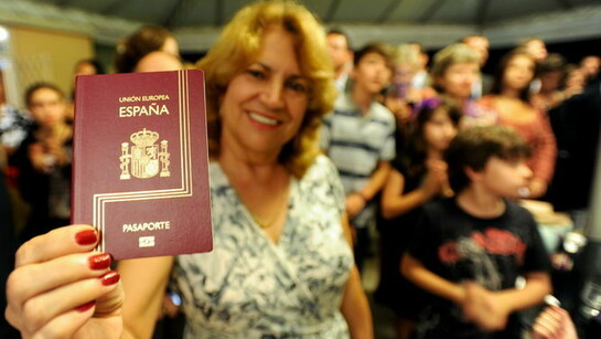 Una mujer muestra su pasaporte español