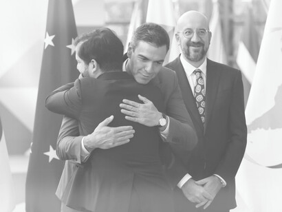 Spain's Prime Minister hugs Chilean President Gabriel Boric as European Council President Charles Michel stands smiling