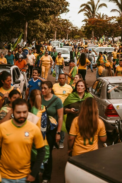 Manifestantes ocupam a via pública, enquanto carros aparecem no cenário da mobilização. Nas redes sociais e nas ruas, a repetição de mensagens pode alimentar certezas e intensificar a polarização, tornando cada vez mais difícil distinguir informação, manipulação e discurso de ódio