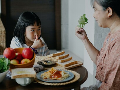 Criança comendo com a mãe