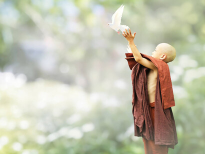 A young Chinese monk sets free a dove which is a symbol of peace in this world