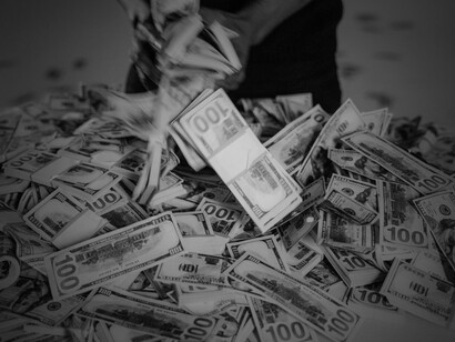 Stack of US dollars in hand, representing bribery and bureaucratic corruption