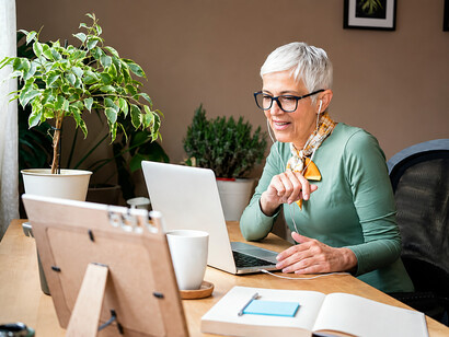 A senior professional participating in online work from home with digital technology