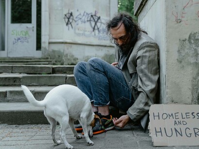 Homeless man plays with dog