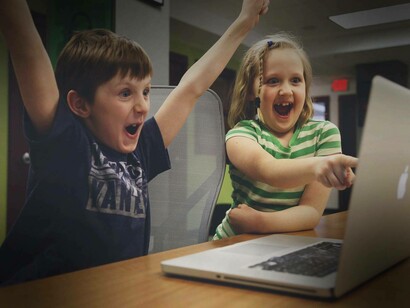 The youth are celebrating their progress after utilizing the laptop