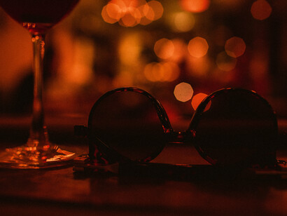Un copa de vino y unas gafas de sol dejadas por un cliente despistado en la barra del Bar Feli