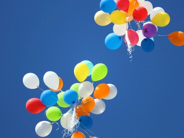 Deux lots de ballons s'envolant dans le ciel, représentant liberté et émancipation
