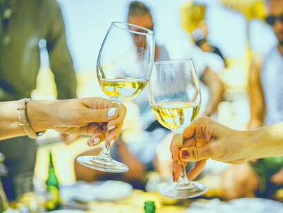 Dos mujeres brindan con copas de vino en una celebración