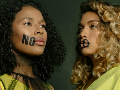 Two women with “no” painted on their faces, symbolising the power of self-respect
