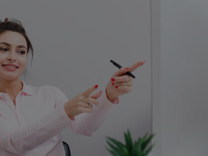 Focused and determined, a female screenwriter points at her computer, shaping her next masterpiece