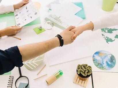 Capture the essence of collaboration with a powerful image of a businessman shaking hands with his partner over a desk, symbolizing successful partnerships and business agreements