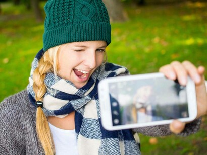 Una chica mostrando su teléfono móvil
