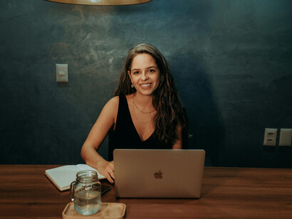 A woman seated at a table working on her laptop, illustrating everyday technology use