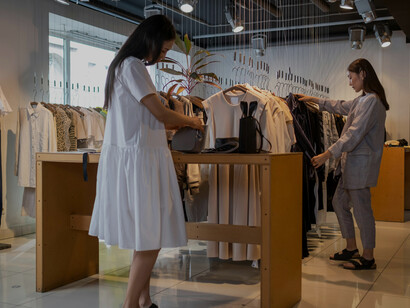 2 womenbrowsing clothing in a sleek, minimalist luxury boutique
