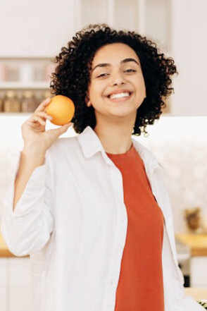 Enjoying a moment with nature's bounty, this orange represents the dietary fibre crucial for supporting beneficial gut bacteria