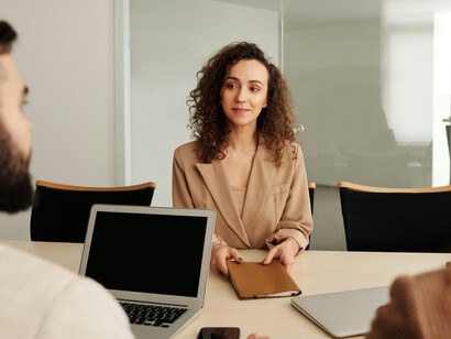 People are having a meeting at the office, and a woman is attending an interview