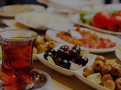 A Turkish-style breakfast unfolds before you, as the table is adorned with an assortment of plates laden with delicious foods and cups brimming with fragrant tea