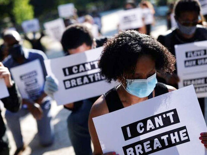 Manifestantes portan carteles con la última frase pronunciada por Eric Garner y George Floyd
