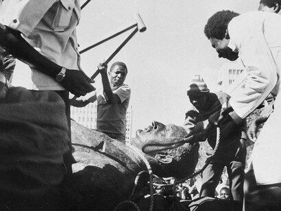 Men beat a statue of British politician Cecil Rhodes in Zimbabwe after the African country formerly known as Rhodesia was granted independence by Britain in 1980