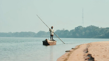 Uomo che pagaia sul fiume Gange, Varanasi, india