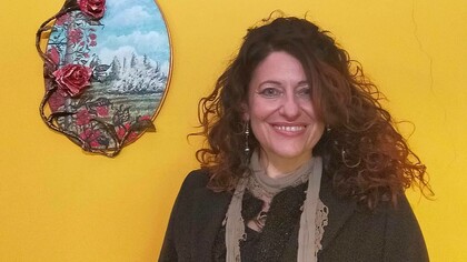 Nora Art next to one of her painted pieces