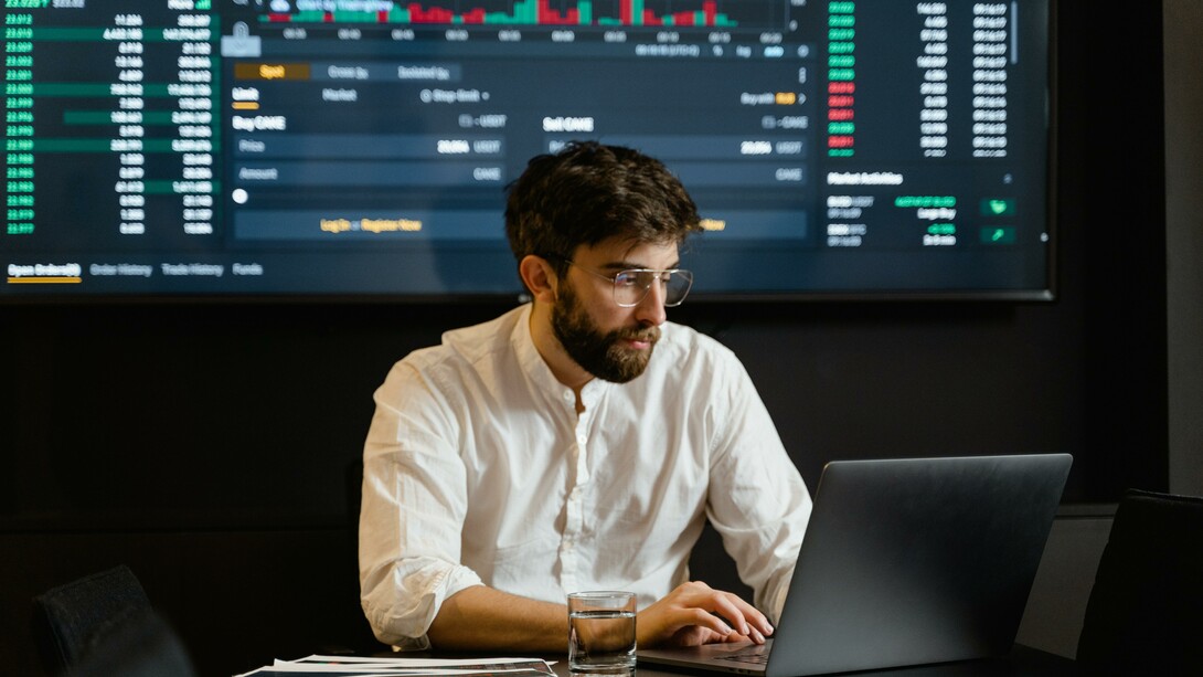 An economist sitting at a desk with a laptop