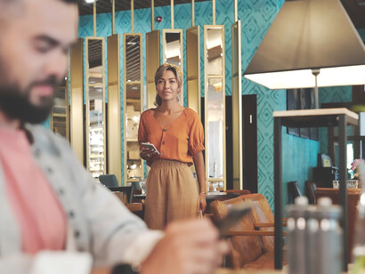 A man and a woman, meeting for their first date, share a moment at a charming venue, sipping wine as they begin to explore the possibilities of connection
