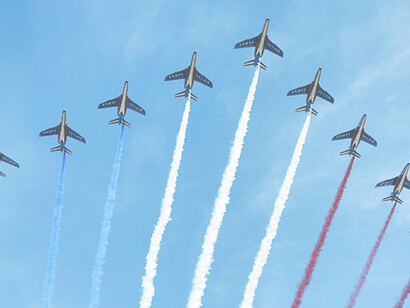 Nine Alpha Jets from the French Air Force fly over the Champs-Elysées, releasing trails of blue, white and red smoke, colours of the French national flag