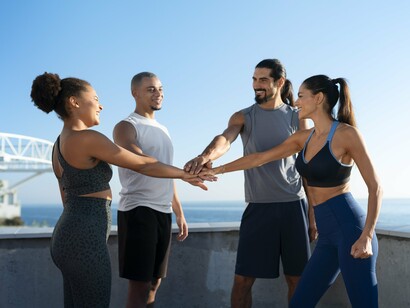 A group of friends join hands in a show of unity and encouragement, reflecting the strong sense of community and mutual support found in marathon running. 