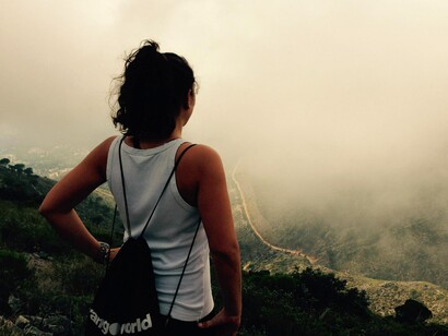 Una viajera observa un valle entre la niebla
