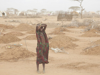 Children have walked for weeks across the desert to get to Dadaab, and many perish on the way. Others have died shortly after arrival. On the edge of the camp, a young girl stands amid the freshly made graves of 70 children, many of whom died of malnutrition
