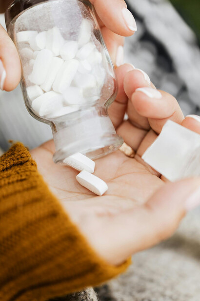 Falcone di pillole erogate su una mano di donna