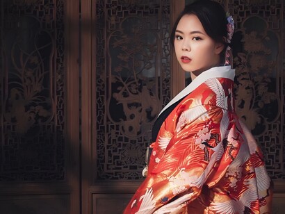 A woman wearing a traditional kimono with an intricate floral pattern, representing the wisdom of designing with fabric efficiency in mind
