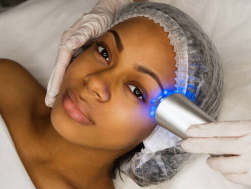 A woman receiving ultrasound chromotherapy treatment in a professional cosmetology session
