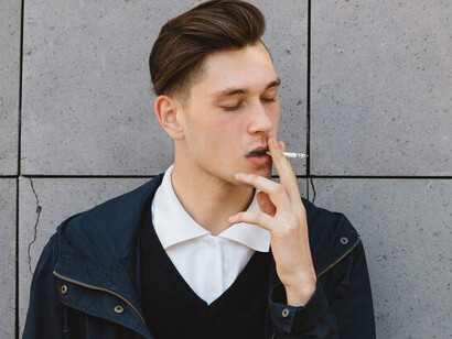 A young man enjoying a cigarette in an outdoor setting