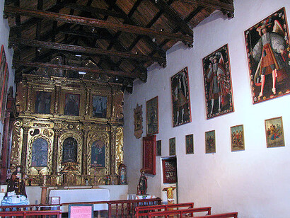 Las alas multicolores, las miradas distantes y los encajes minuciosos revelan una estética única, donde la devoción se funde con la teatralidad barroca