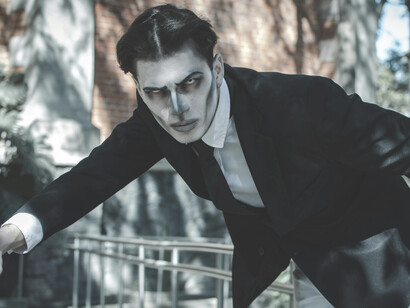 Dramatic Gothic portrait of a man with makeup in sunlight