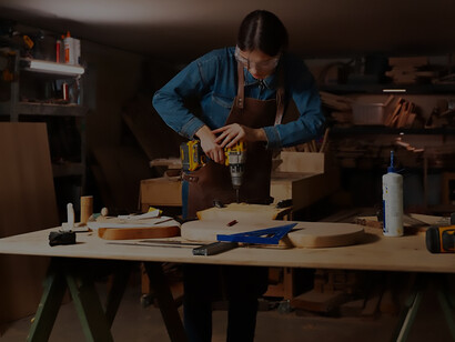 Embrace the spirit of innovation with a compelling image of a girl in the garage, skillfully engaged in woodcutting, showcasing determination and creativity in action