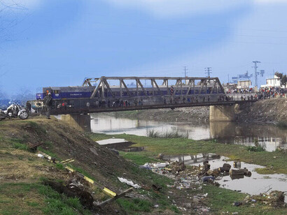 Formación del FCGB pasando por el puente del río Matanza vista desde Villa La Salada, Tapiales. Se observa el agente policial sobre la locomotora por la cercanía con la feria de "La Saladita", 2012. Partido de La Matanza, provincia de Buenos Aires, Argentina