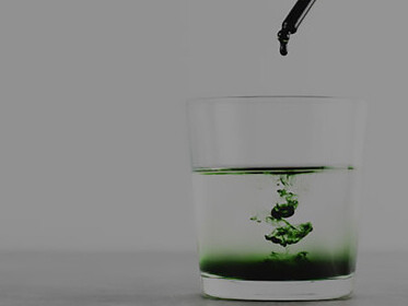 Glass of water with liquid chlorophyll, symbolizing superfood, healthy diet, and detoxification concept