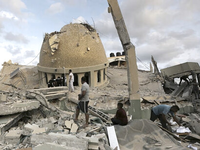 Gente se reune afuera de una mezquita destruida en Khan Younis, Franja de Gaza, el 8 de octubre de 2023