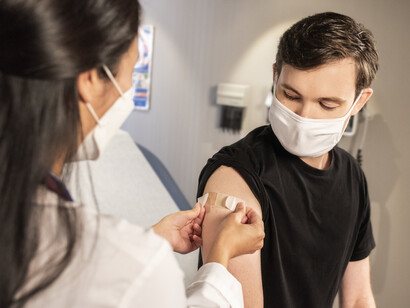 A young man receives his booster shot