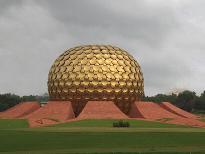 Auroville is an experimental township situated primarily in Tamil Nadu’s Viluppuram district, with some areas extending into the Union Territory of Puducherry. Established in 1968 by Mirra Alfassa, known as “The Mother,” it was designed by architect Roger Anger as a space for collective living and human unity